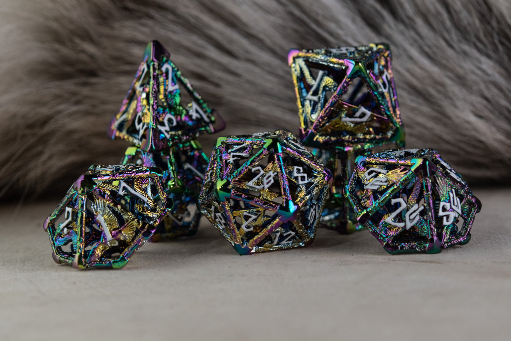 A set of iridescent hollow metal dice inincluding various shapes such as a d4, d6, d8, d10, d12, and d20, displayed on a reflective surface.