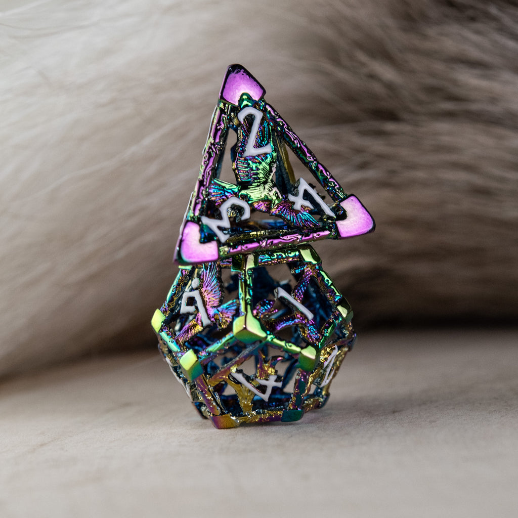 A set of iridescent hollow metal dice inincluding various shapes such as a d4, d6, d8, d10, d12, and d20, displayed on a reflective surface.