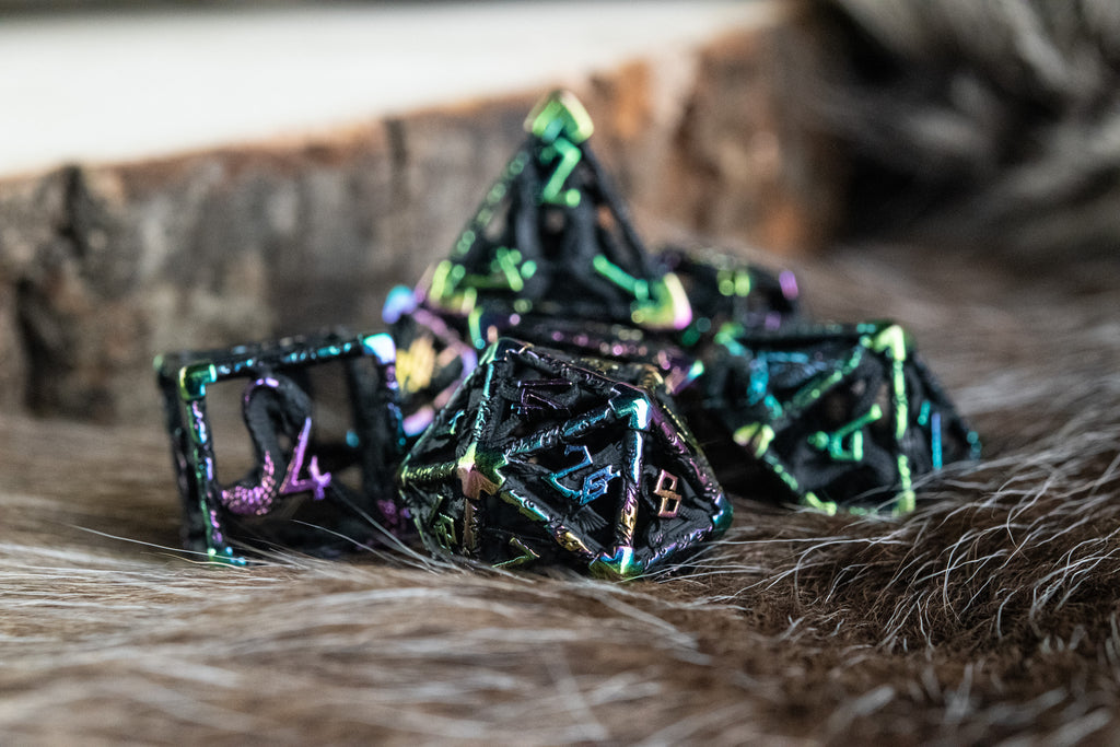 A set of black and iridescent hollow metal dice with embossed numbers, including various shapes commonly used in RPGs.
