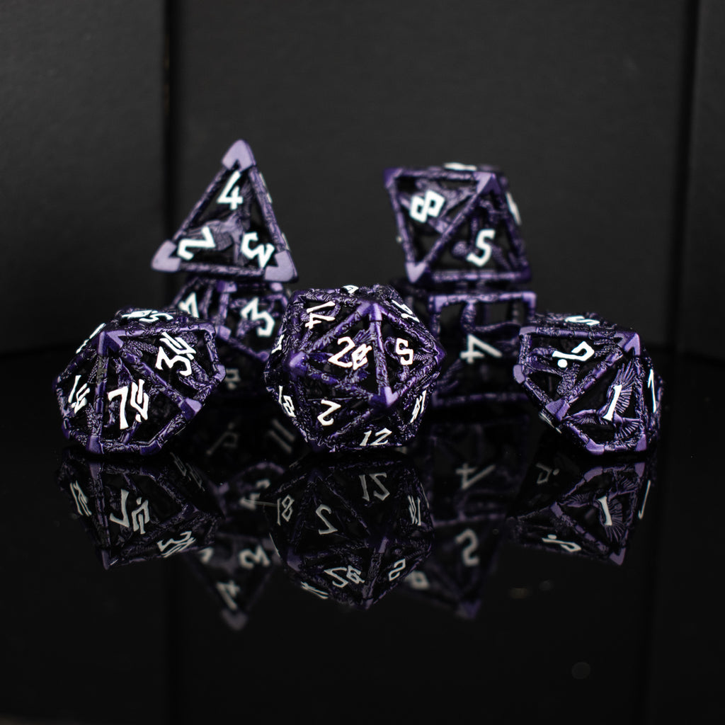 A set of purple hollow metal dice with white embossed numbers, including various shapes such as a d4, d6, d8, d10, d12, and d20, displayed on a reflective surface.