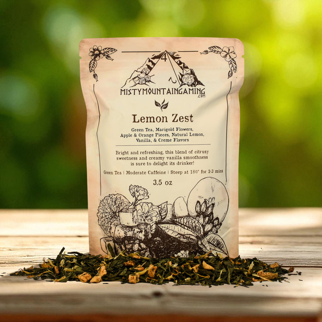 Misty Mountain Gaming Tea package labeled 'Lemon Zest' with dried tea leaves on a wooden surface