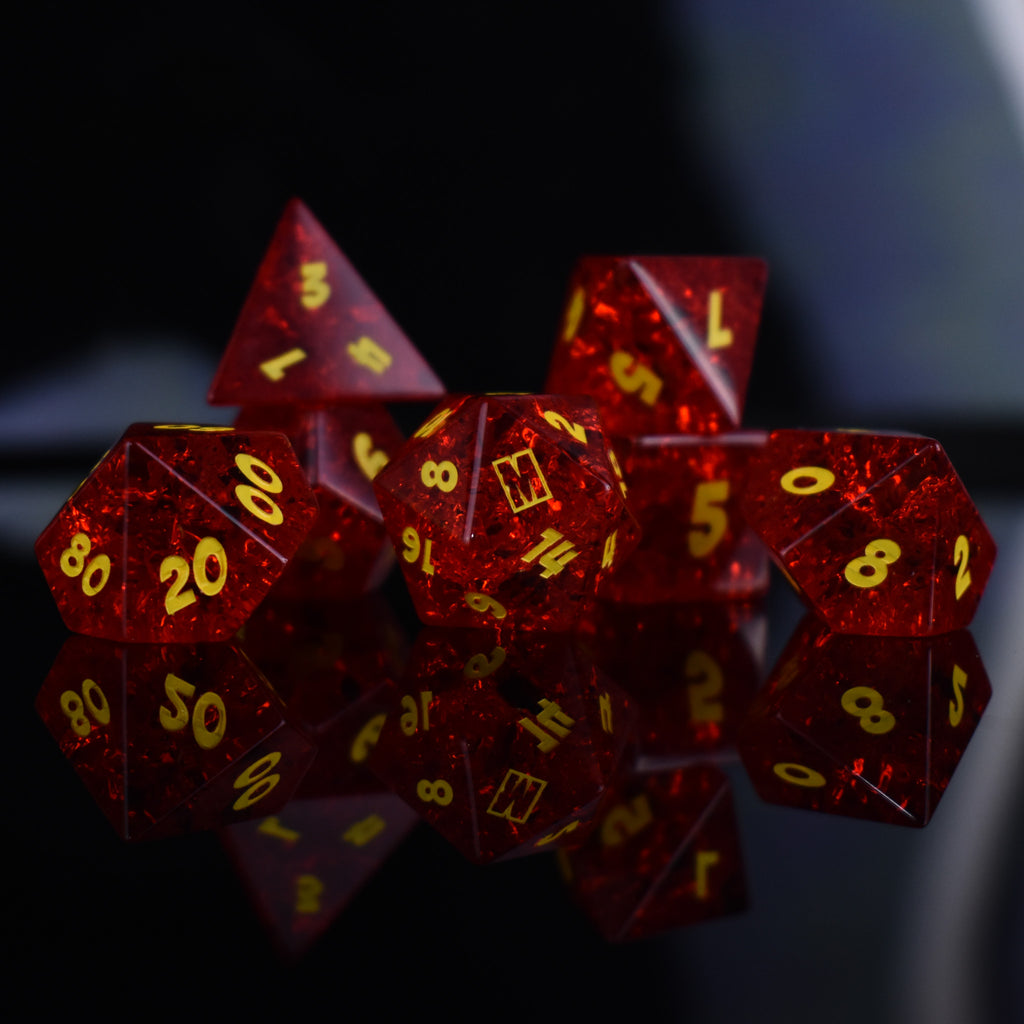 A set of red glass dice with engraved numbers, displayed in front of a Megacon Orlando backdrop.