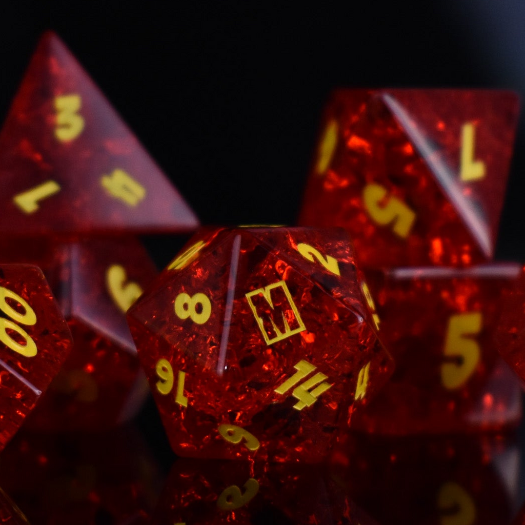 A set of red glass dice with engraved numbers, displayed in front of a Megacon Orlando backdrop.