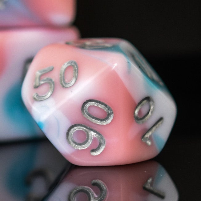 A set of baby blue, pink and white acrylic dnd dice with silver numbers for playing tabletop games