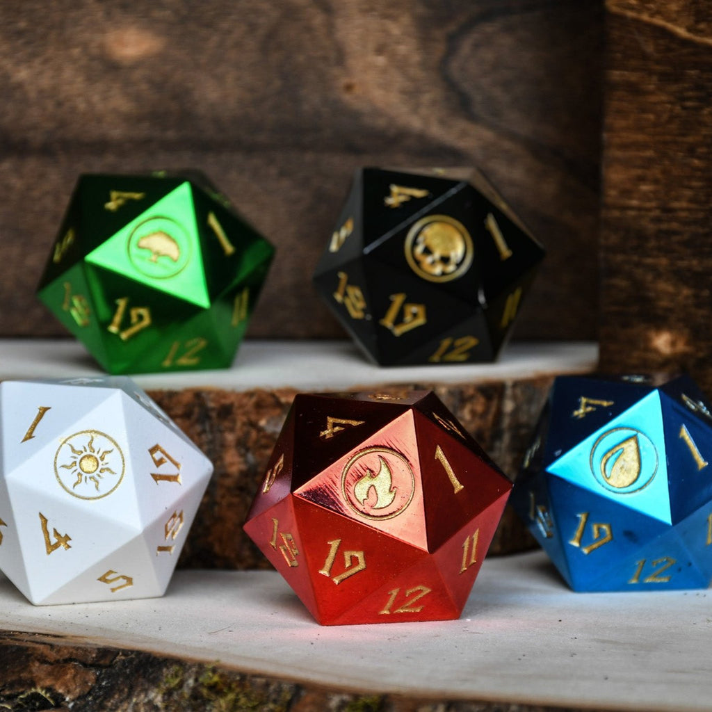 A set of five metal d20 spindown dice in black, green, red, blue, and white, each with different numbers and icons on the faces.
