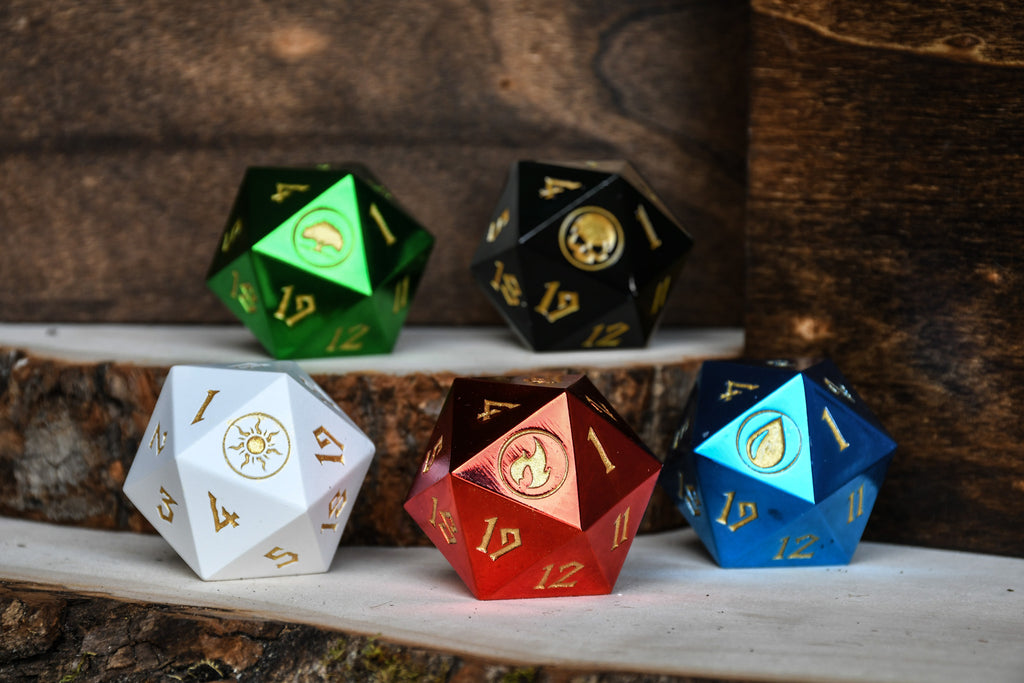 A set of five metal d20 spindown dice in black, green, red, blue, and white, each with different numbers and icons on the faces.