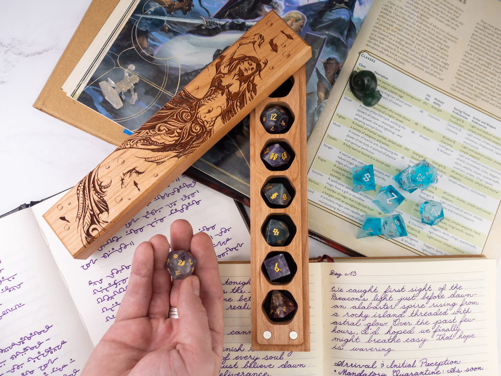 Wooden dice tray with engraved design on a table with gaming materials