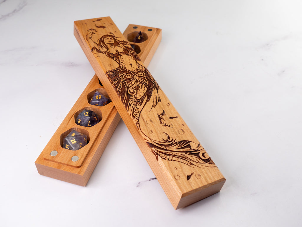 Wooden dice trays with engraved designs on a white background