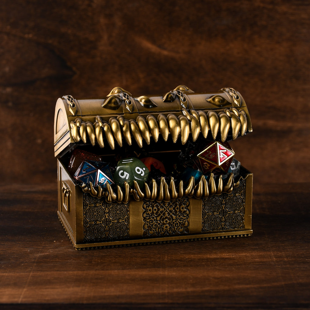 A gold-colored metal mimic chest filled with multicolored dice, set against a wooden background.