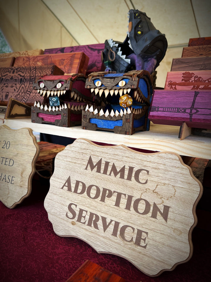 A wooden mimic storage box with blue interior, resembling a fantasy creature, used as a dice vault with dice inside.