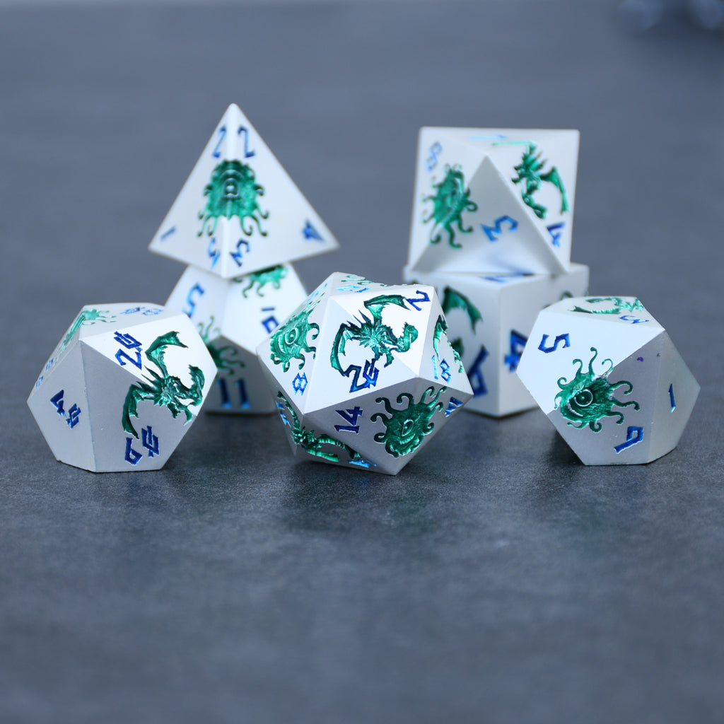 A set of silver metal dnd dice with green monster patterns on them and blue numbering