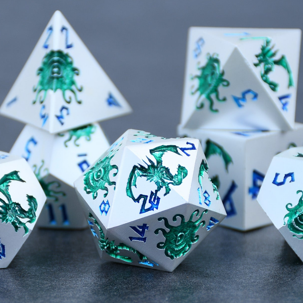A set of silver metal dnd dice with green monster patterns on them and blue numbering
