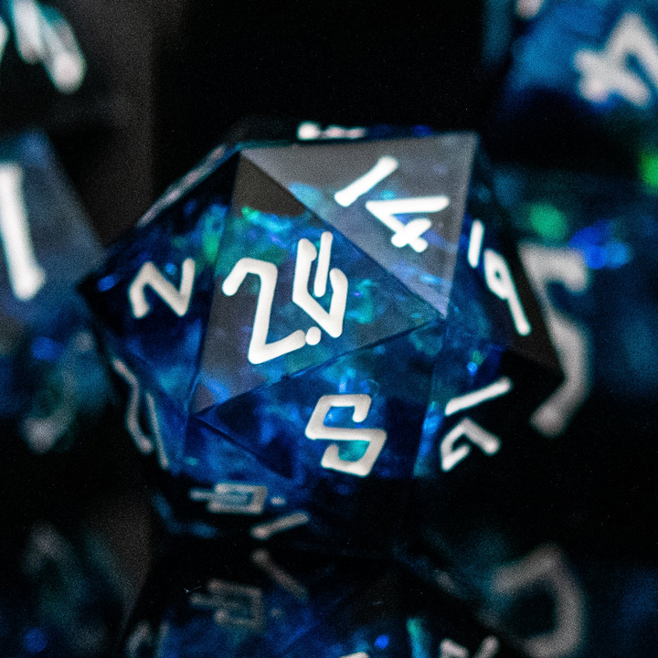 Close-up of a blue polyhedral dice with white numbers on a dark background