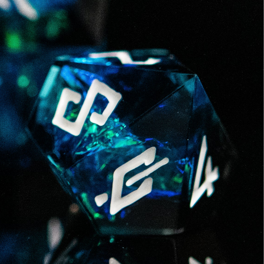 Close-up of a blue and green polyhedral die with white numbers on a dark background