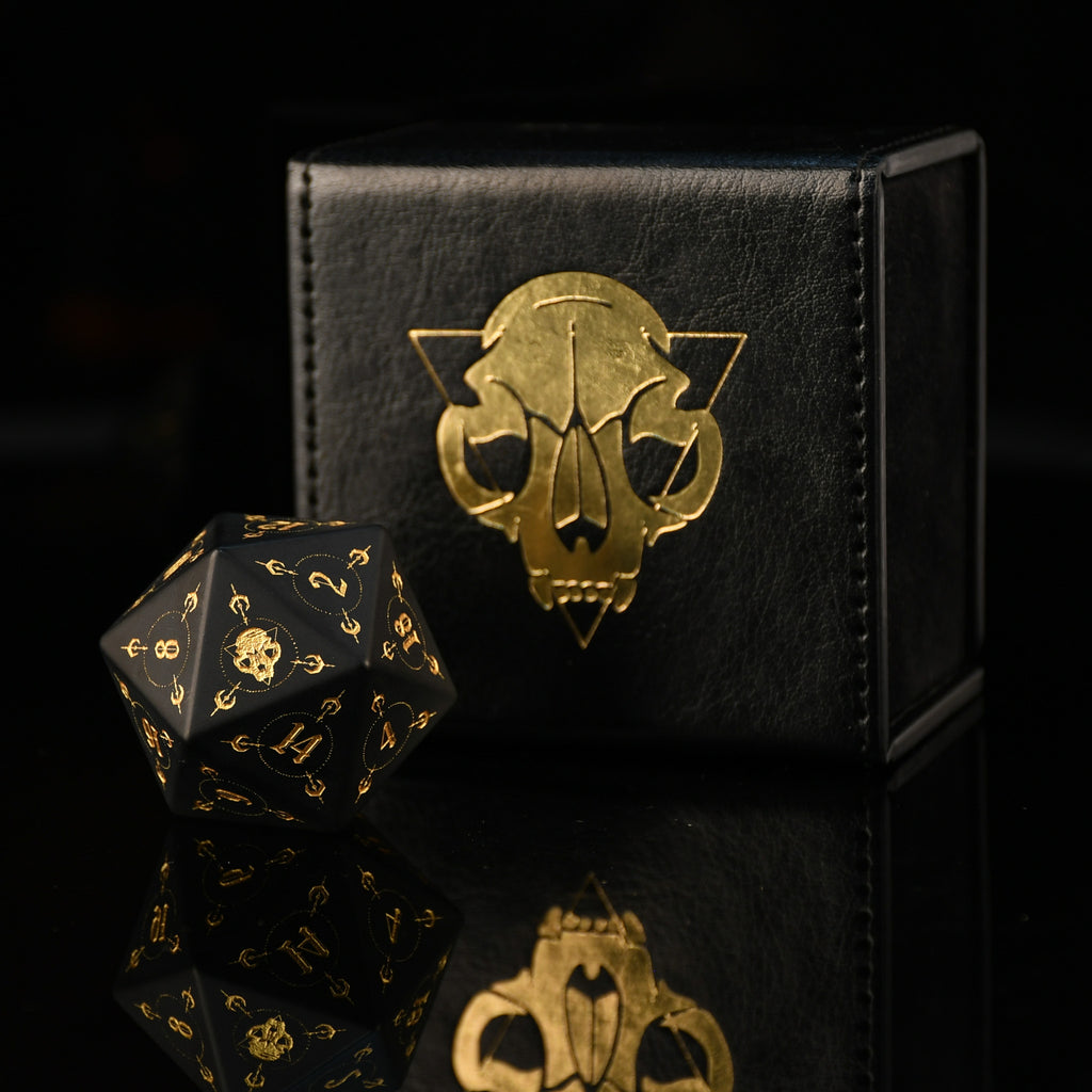 Black dice set with gold details on a black box featuring a gold emblem.