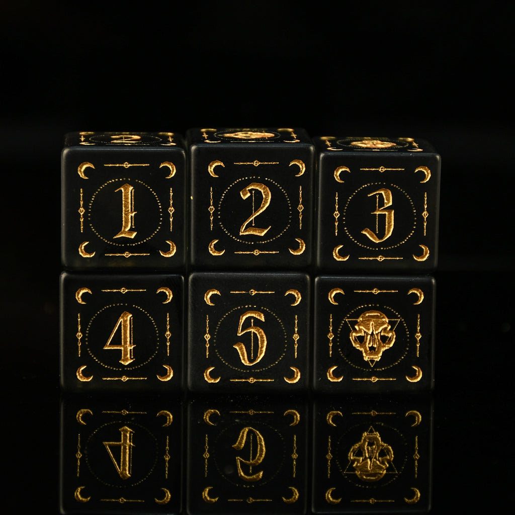 Black dice with gold numbering and symbols on a black background