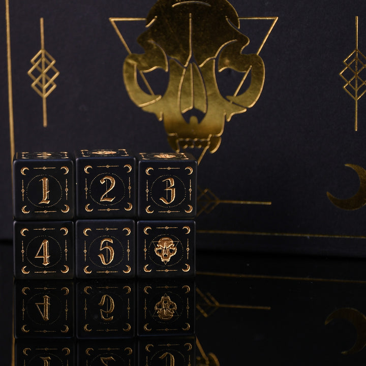 Black frosted glass d6 dice set with gold numbering and symbols on a dark background