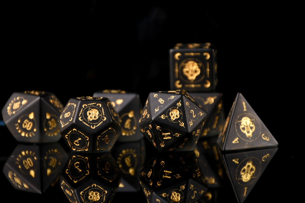 Black dice set with gold markings on a reflective black surface