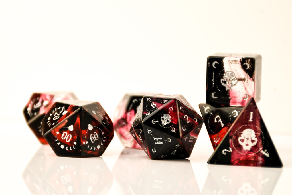 Set of black and red dice with skull designs on a white background