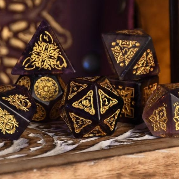Set of ornate dice with gold patterns on a wooden surface