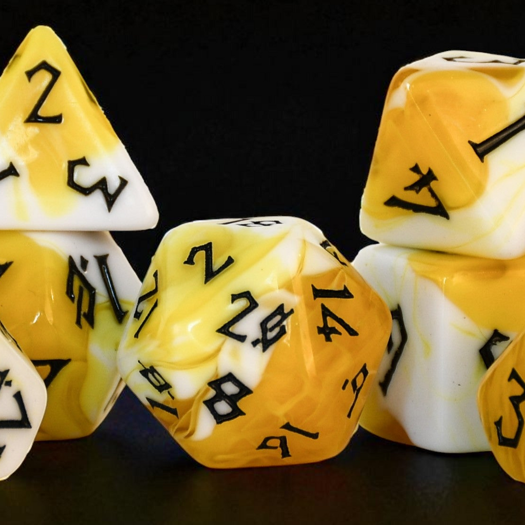 Set of yellow and white polyhedral dice acrylic dice with black numbers inspired by popcorn on a black background