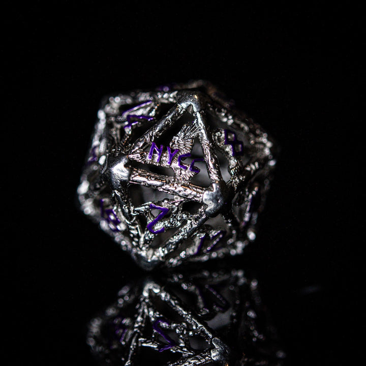 A set of sterling silver hollow dice with purple embossed numbers, displayed on a reflective surface.