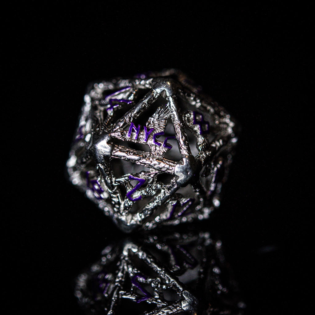 A set of sterling silver hollow dice with purple embossed numbers, displayed on a reflective surface.