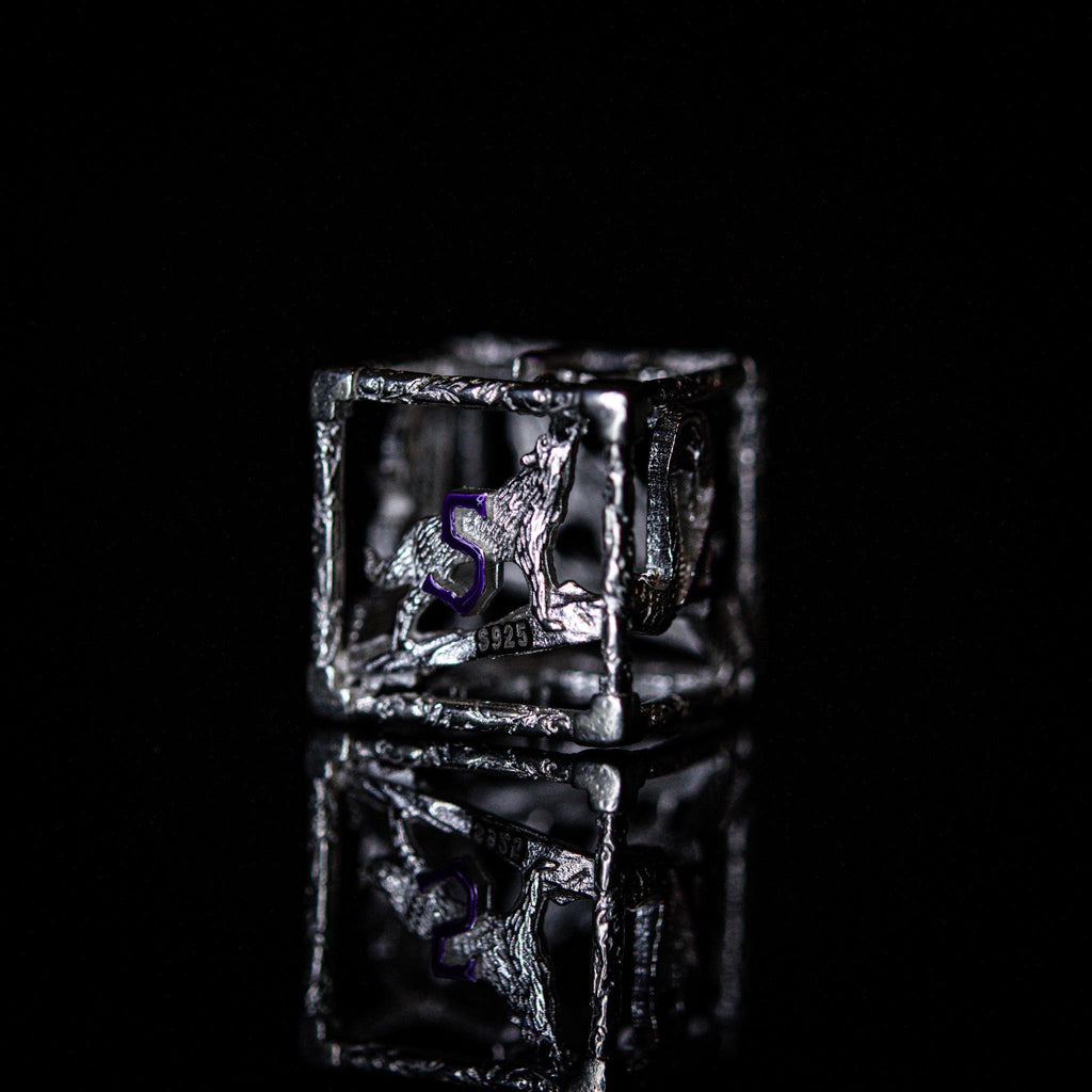 A set of sterling silver hollow dice with purple embossed numbers, displayed on a reflective surface.