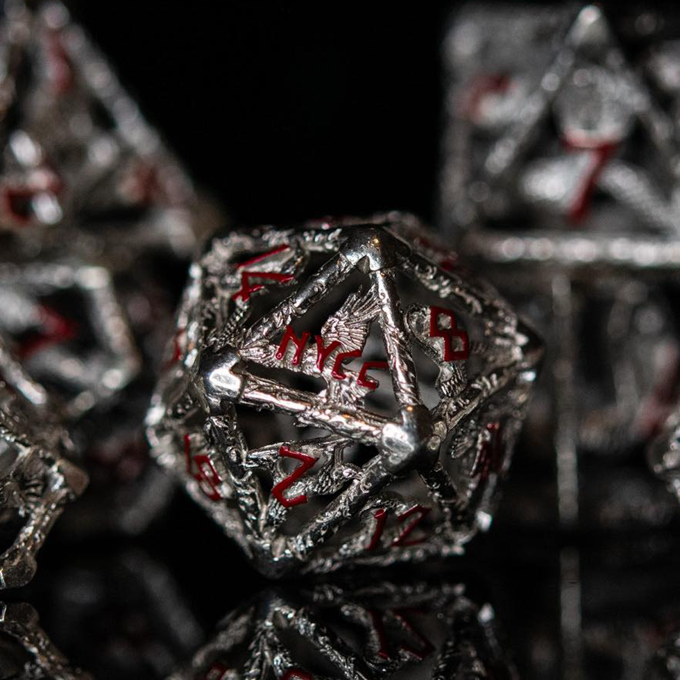 Close-up of metallic polyhedral hollow dice with red numbering on a dark background