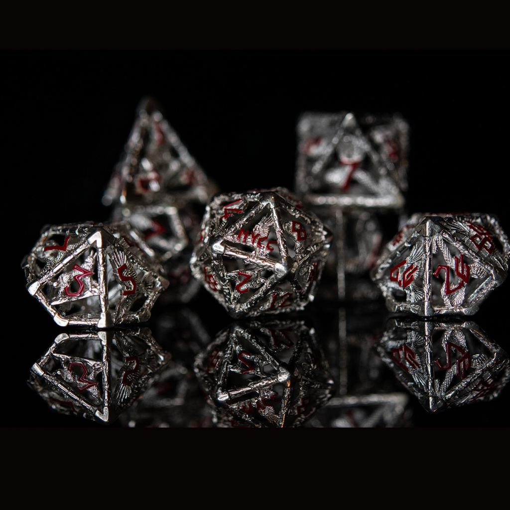 A set of sterling silver dice with red embossed numbers, displayed on a reflective surface.