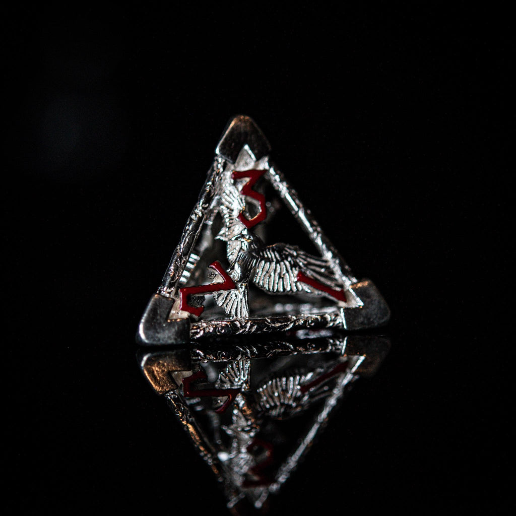 A set of sterling silver dice with red embossed numbers, displayed on a reflective surface.