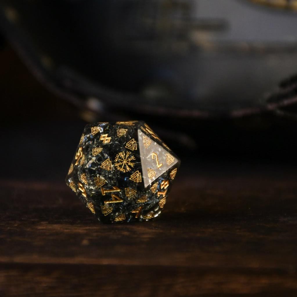A set of black shattered glass polyhedral dice with Nordic designs