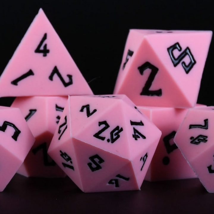 A set of pink silicone dice with black numbering, including various shapes typical for role-playing games.