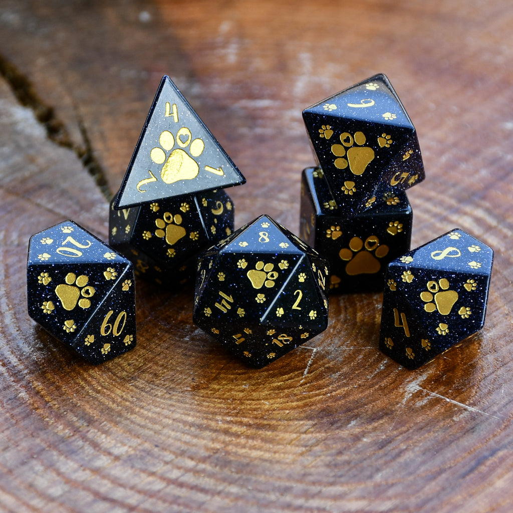 Puppy Paws Blue Sandstone Dice Set with gold paw prints and numbers on a wooden surface