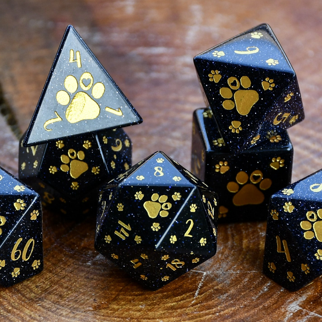 Puppy Paws Blue Sandstone Dice Set with gold paw prints and numbers on a wooden surface