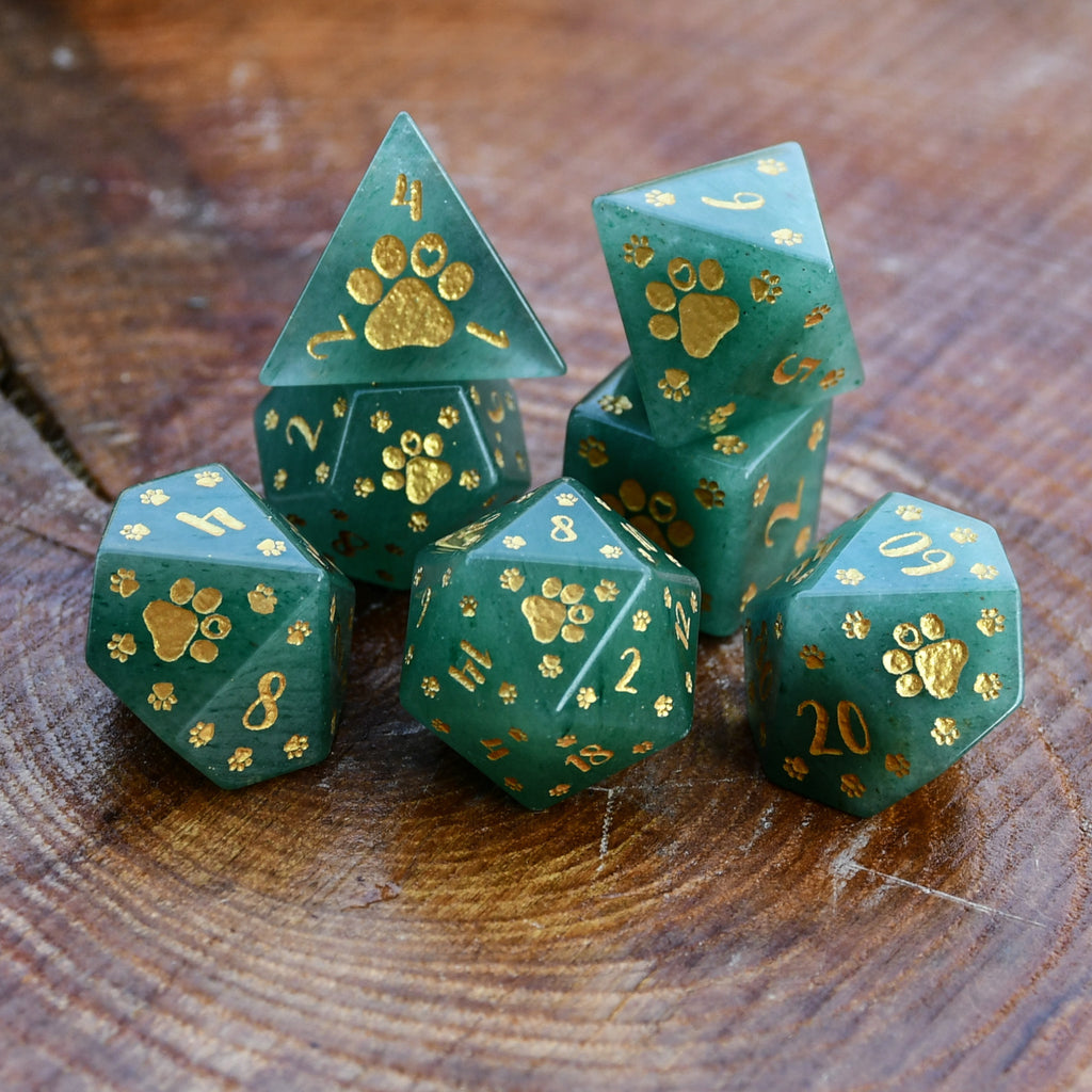 Puppy Paws Green Aventurine Dice Set  with gold paw prints on a wooden surface