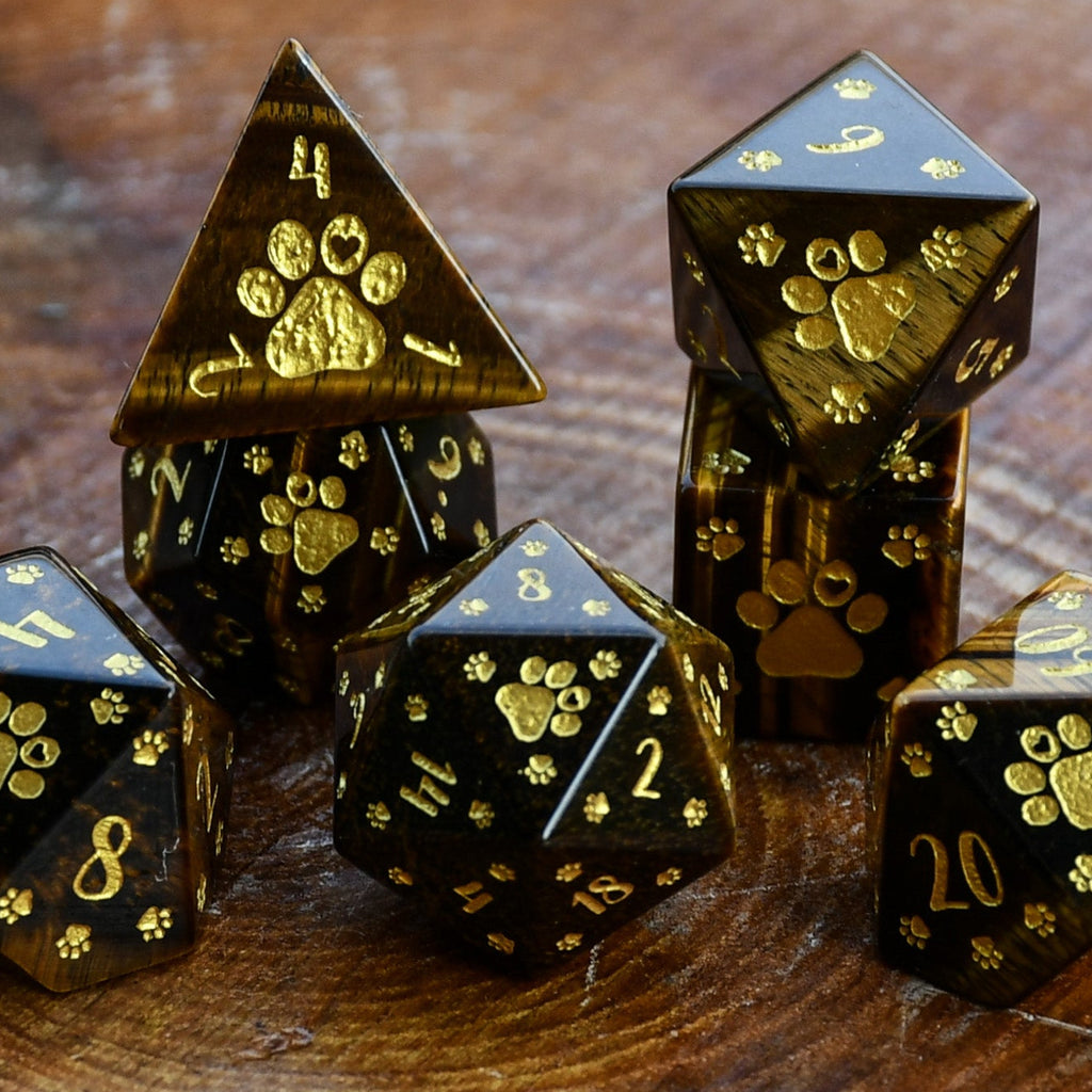 Puppy Paws Yellow Tiger Eye Dice Set with gold paw prints on a wooden surface