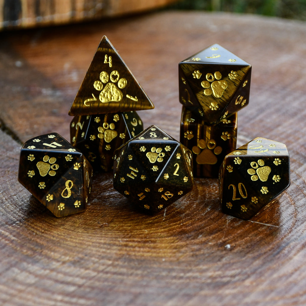 Puppy Paws Yellow Tiger Eye Dice Set with gold paw prints on a wooden surface