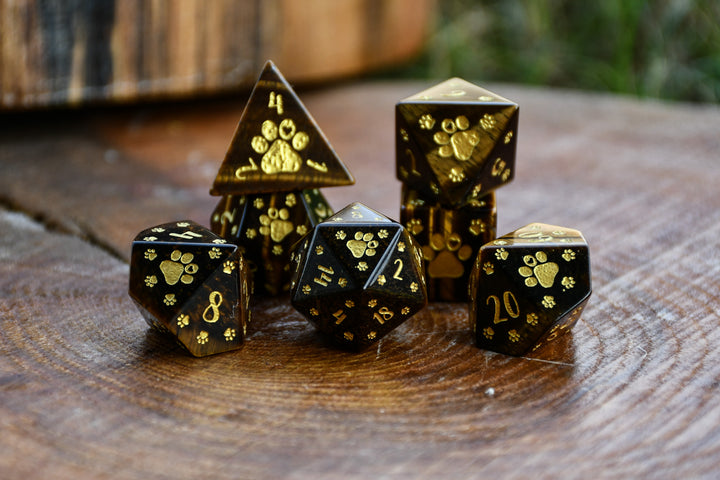 Puppy Paws Yellow Tiger Eye Dice Set with gold paw prints on a wooden surface
