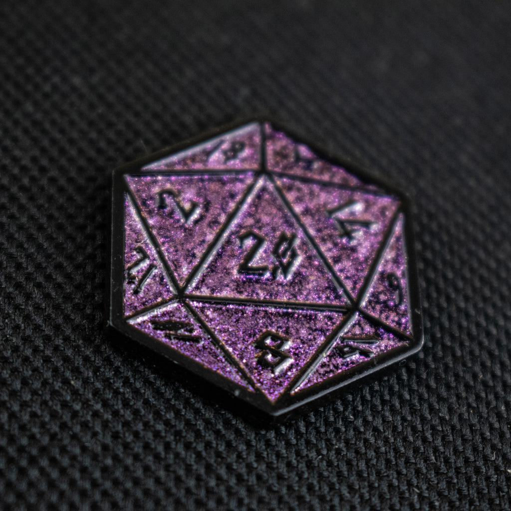 One purple glitter d20 dice pin on a dark background