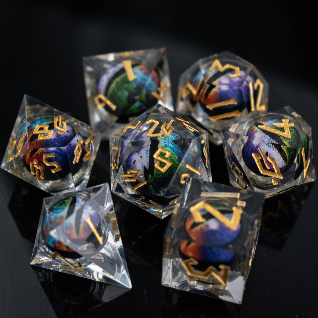 A set of multicolored liquid core resin dice with eye designs inside, displayed on a dark surface.