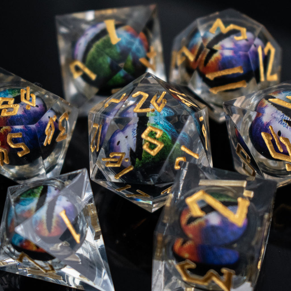 A set of multicolored liquid core resin dice with eye designs inside, displayed on a dark surface.