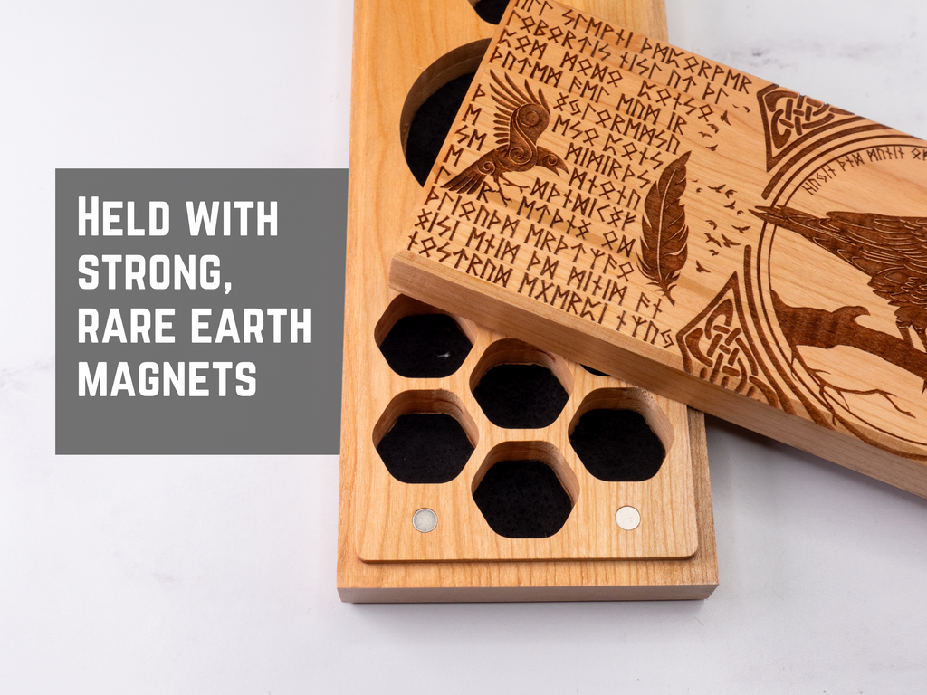 Wooden dice vault with engraved designs and text, held together by magnets on a white background.