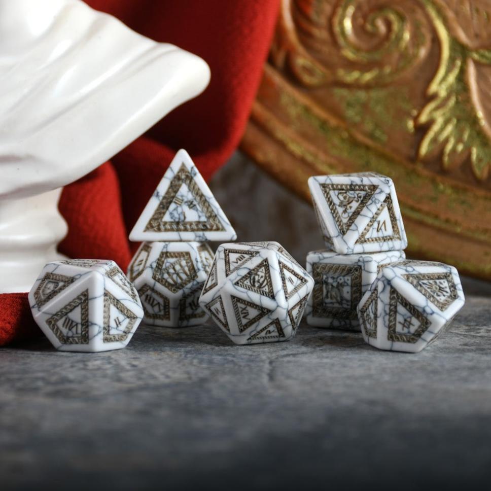 A set of roman inspired white howlite dice with intricate engravings, including a d4, d6, d8, two d10, d12, and d20, displayed on a dark surface.