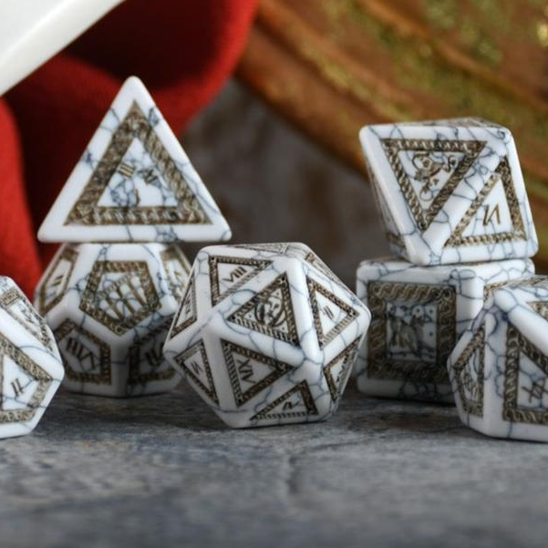 Set of polyhedral dice with intricate designs on a neutral background