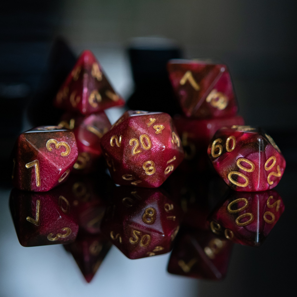 Set of red polyhedral dice with gold numbers on a reflective surface.