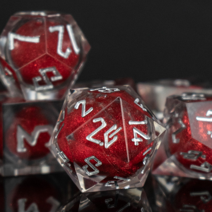 Red polyhedral dice with white numbers on a reflective black surface