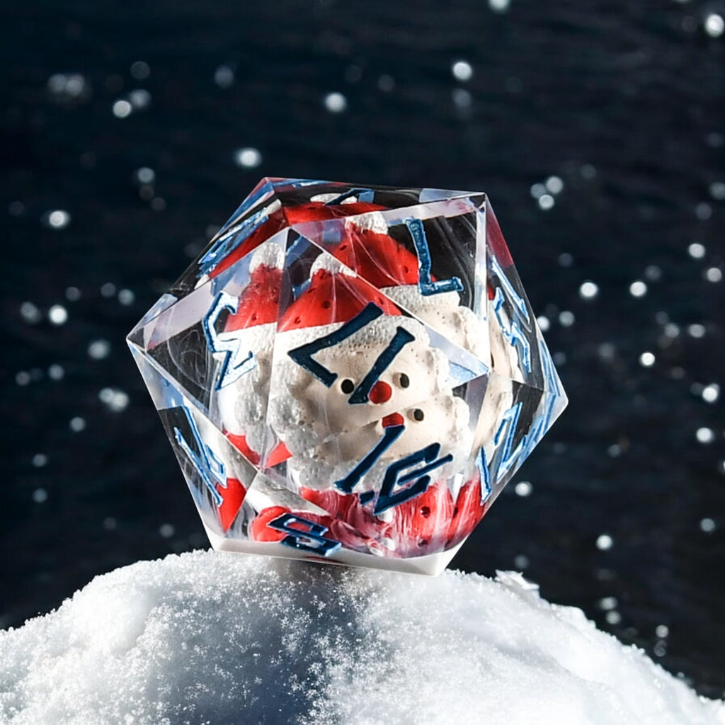 A resin dice set with hand-painted numbers and a small hand-painted Santa in the middle, placed on a snow-like surface with a dark background.