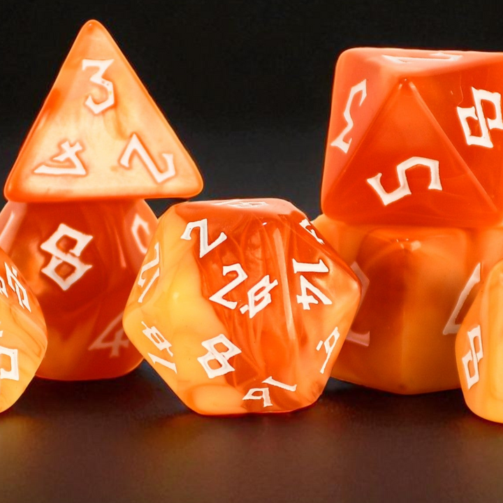 Set of orange polyhedral dice with white numbering on a dark background
