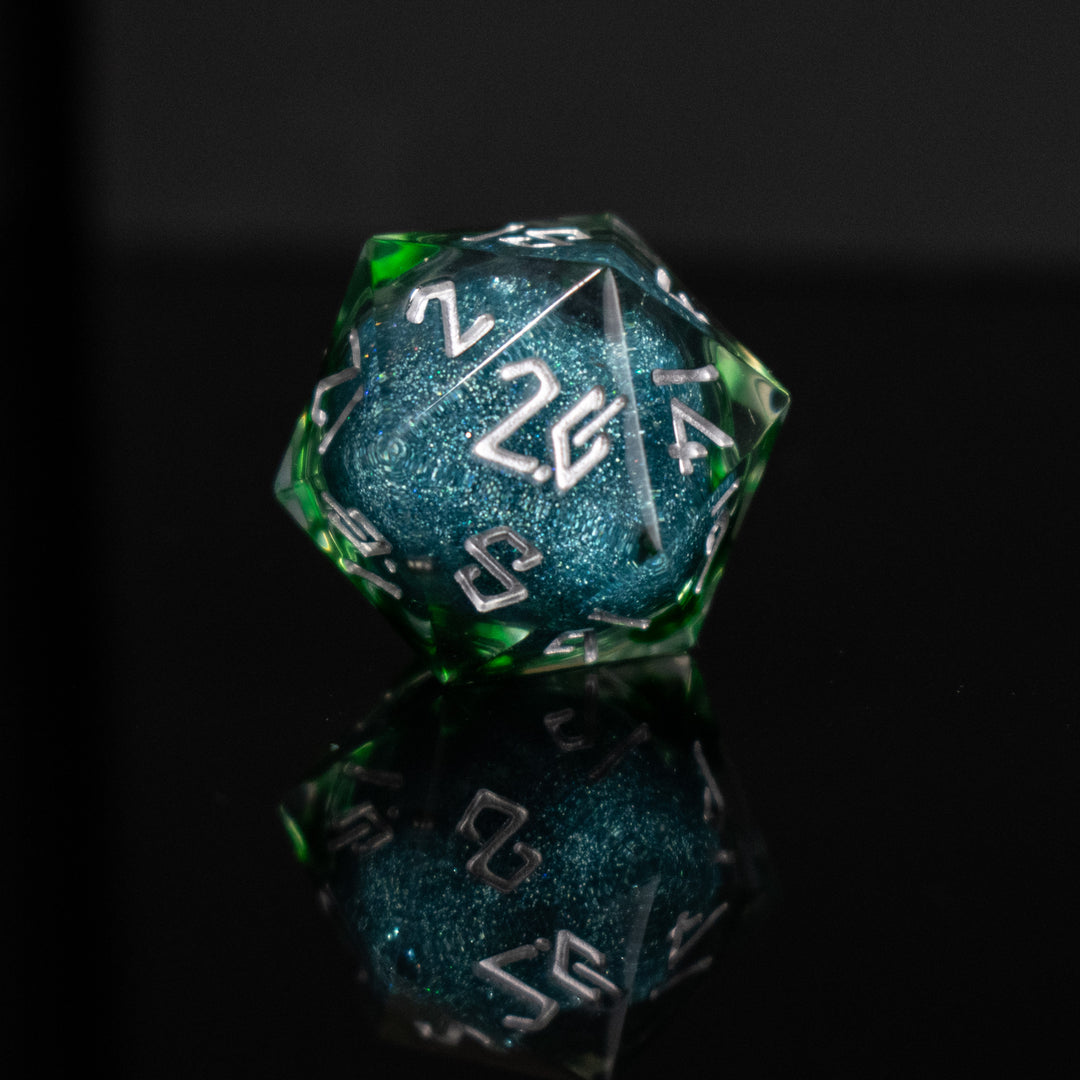 Set of green and blue polyhedral dice with white numbers on a reflective surface.